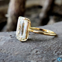 4 prong claw setting holding an emerald moissanite gemstone.