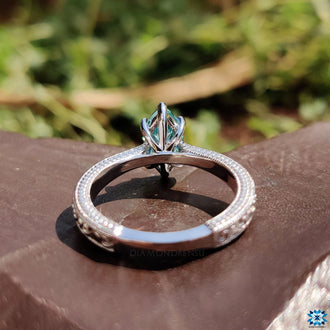 V prong setting holding a brilliant center stone.