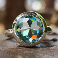 A stunning bezel setting engagement ring showcasing a round cut moissanite in a handmade jewelry design.