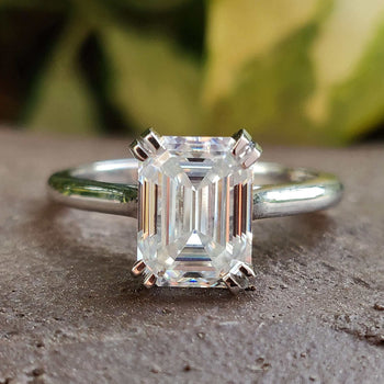 A beautiful emerald cut moissanite ring in classic design.