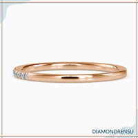 Gold eternity band with round diamonds and minimalist band style.