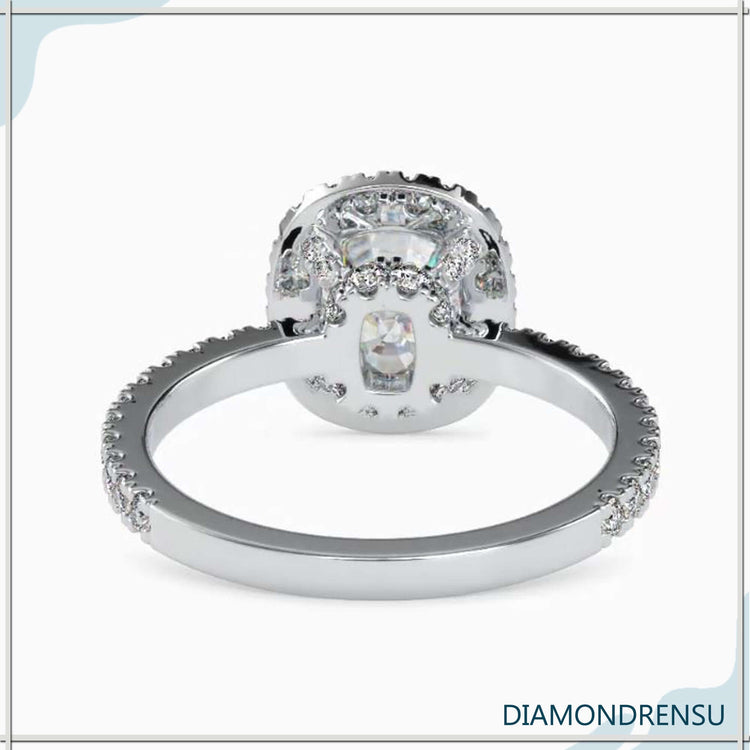 Side stone engagement ring with a cushion cut center and diamond accents.