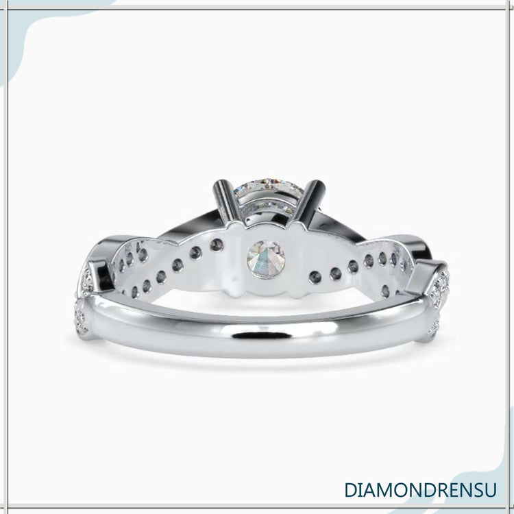 Timeless round cut diamond ring with a twisted band and pave accents.