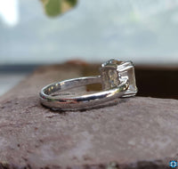 Moissanite Asscher cut engagement ring shimmering in natural light.