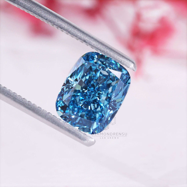 Elongated cushion cut diamond appears in vivid blue lab grown form.