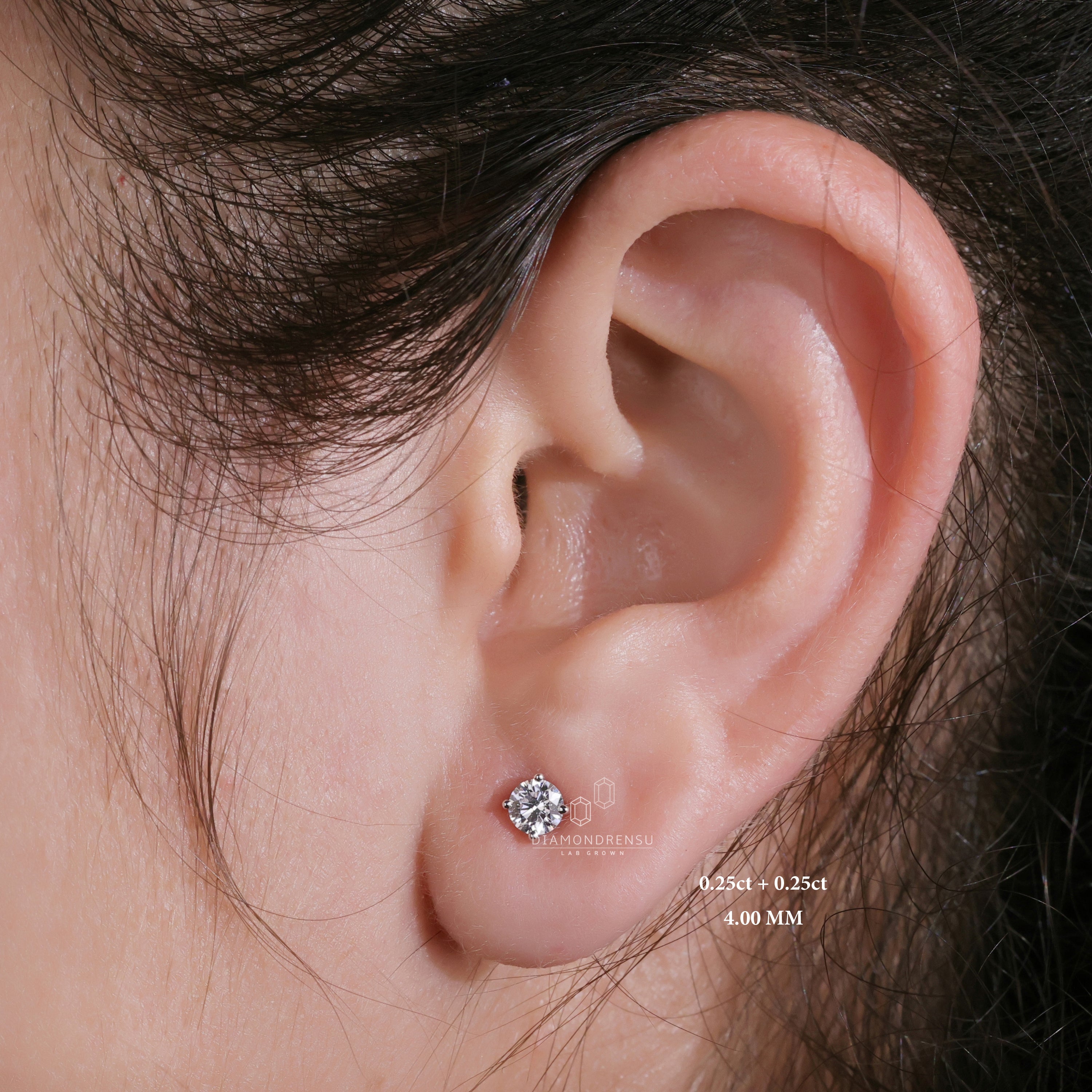Woman wearing lab grown diamond stud earrings, close-up on her ear.