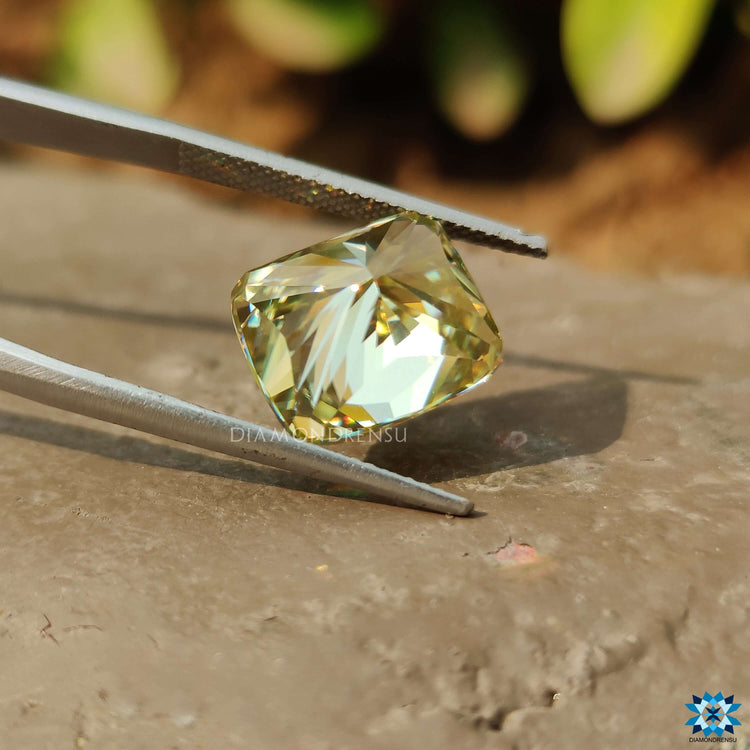 Yellow Cushion Cut moissanite shown in loose form.