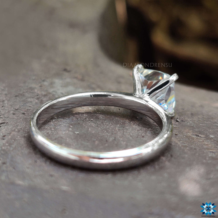 Moissanite solitaire ring crafted with intricate tab prongs.