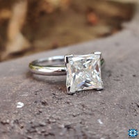 Solitaire engagement ring with a dazzling moissanite stone in a classic princess cut design.