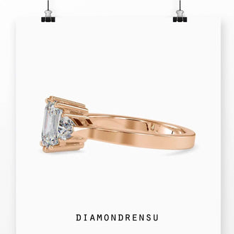 Elegant engagement ring basket setting featuring a three stone emerald cut design.