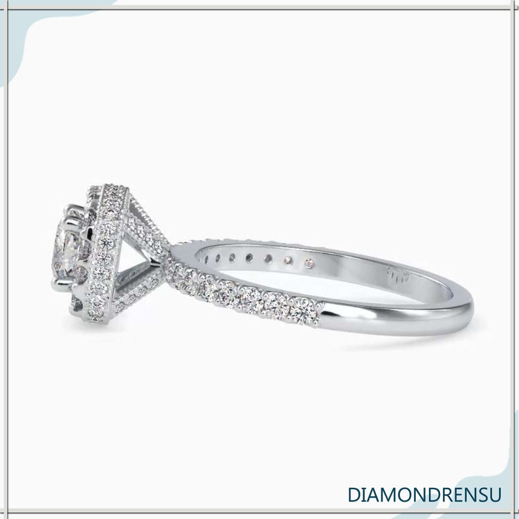 Four prong engagement ring with a cushion cut diamond and a hidden halo pave design.