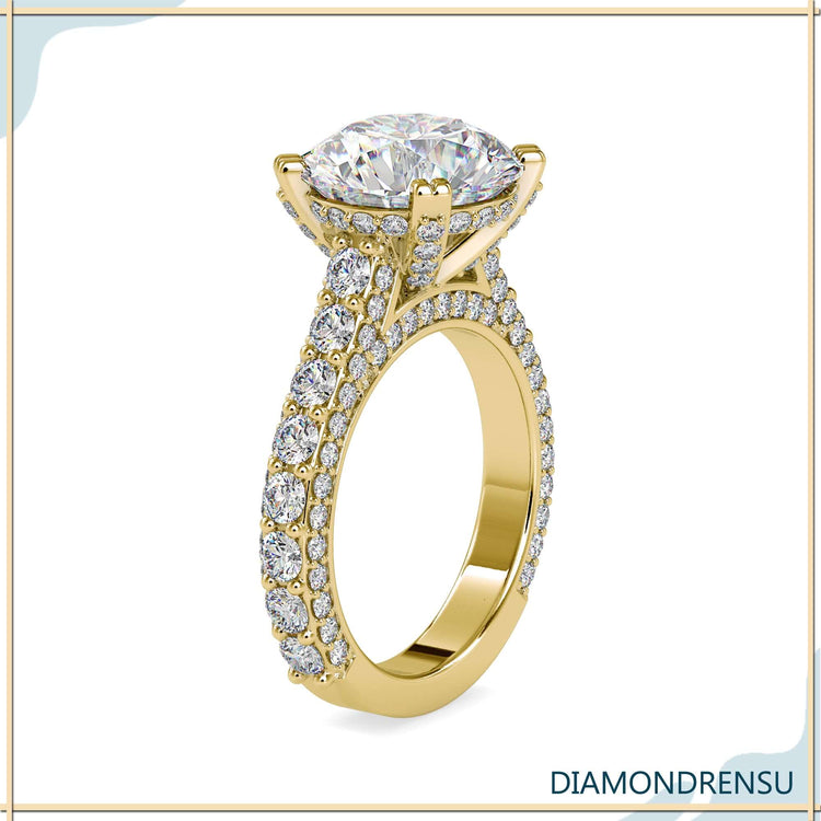 Pave engagement ring setting with a round diamond and side stones.