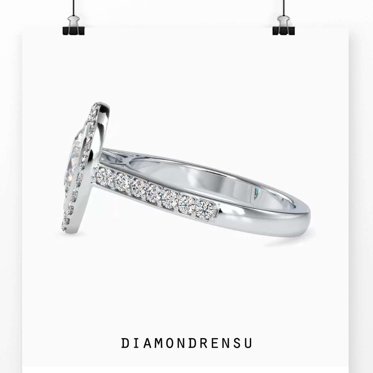 Pear shaped halo ring with bridge setting and pave diamonds.