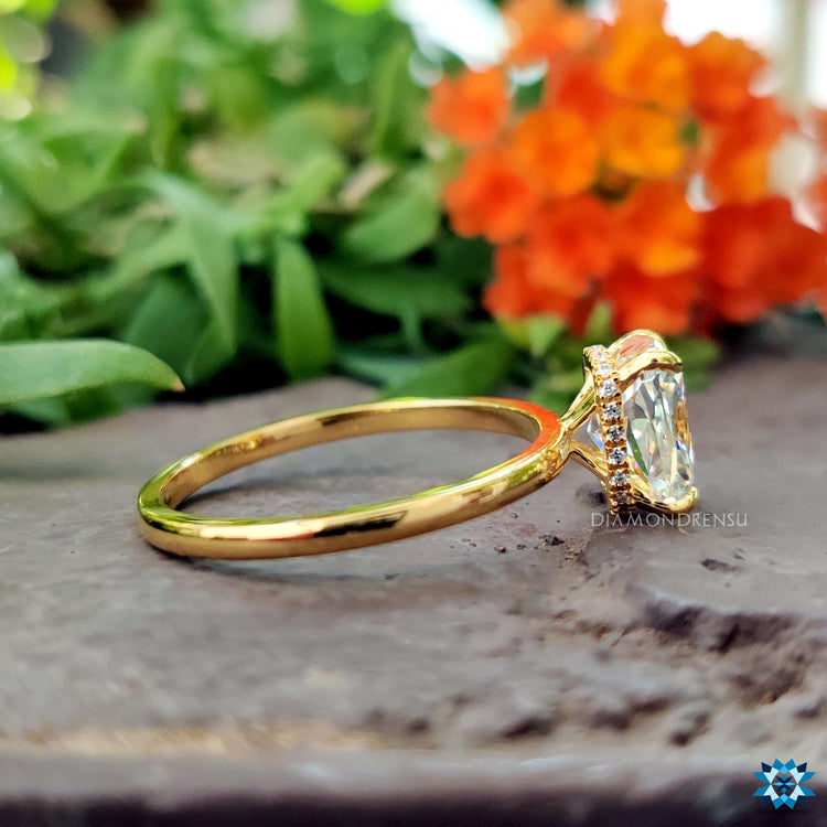 A delicate cushion engagement ring set in yellow gold for a minimalist aesthetic.