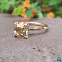 Sparkling cushion cut moissanite ring with a 4-prong diamond setting for added brilliance.