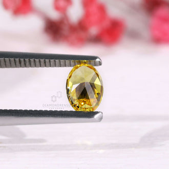 Fancy vivid yellow oval cut diamond shown as a loose stone.