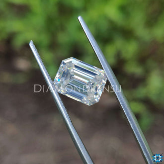 Near colorless moissanite reflecting emerald cut moissanite facets.