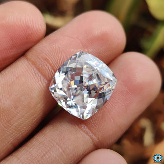 Loose moissanite stone rests above moissanite loose stones.