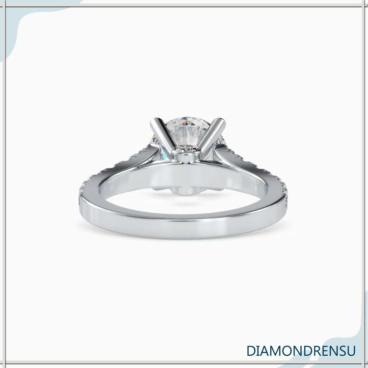 Round cut diamond engagement ring featuring a peek a boo diamond
