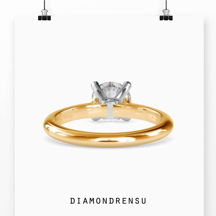 Handmade round solitaire engagement ring with a peek-a-boo diamond accent, available in rose, yellow, or white gold.