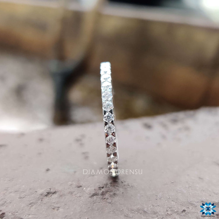 Round wedding band designed with sparkling moissanite stones.
