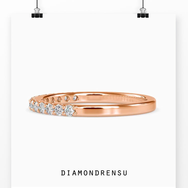 Rose gold wedding band with shared prong setting and round diamonds.