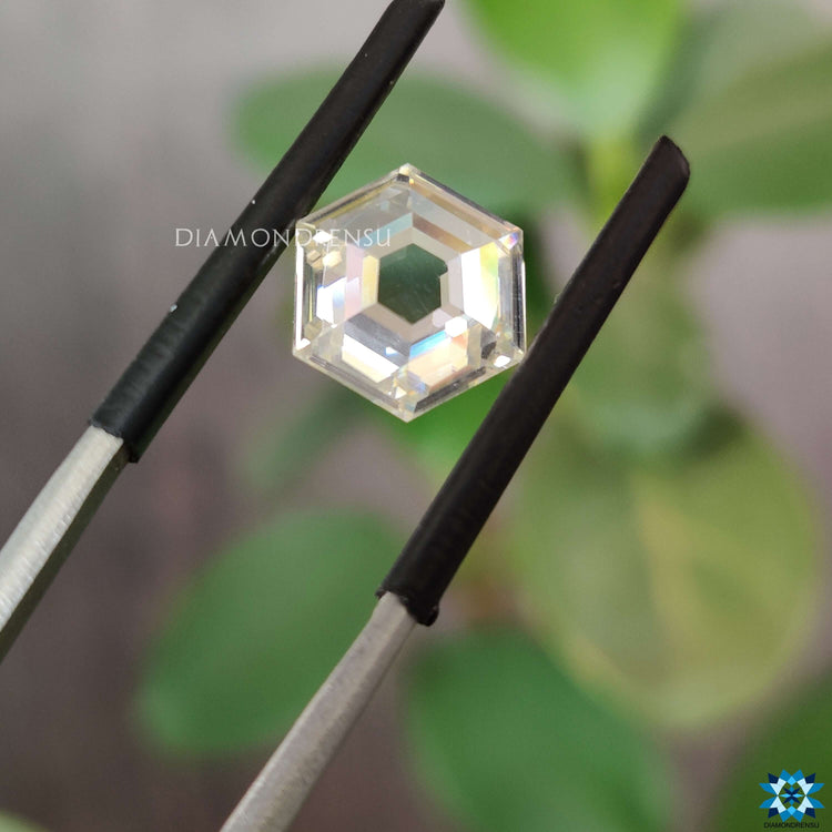 Near colorless moissanite glowing beside rose cut hexagon.