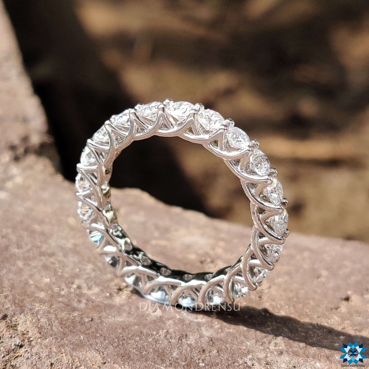 Shared prong eternity band with a trellis design for added elegance.