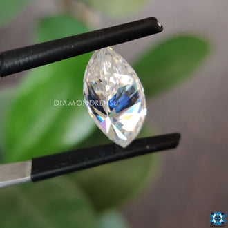 Loose marquise stone shimmering next to moissanite marquise loose stone.