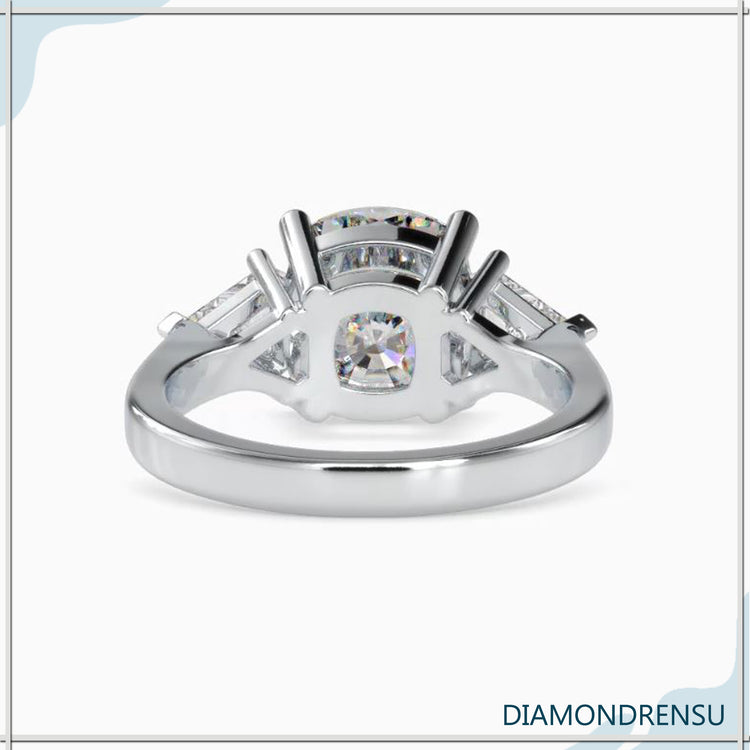 Kite cut three stone ring with cushion cut center diamond and side stones