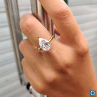 A handmade engagement pear-shaped ring crafted with precision, highlighting its colourless moissanite centre stone.