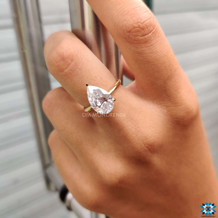 A handmade engagement pear-shaped ring crafted with precision, highlighting its colourless moissanite centre stone.