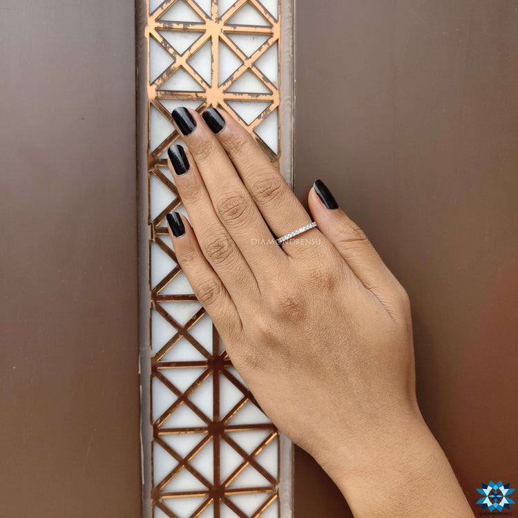 Full eternity band with round moissanite gems in prong setting.