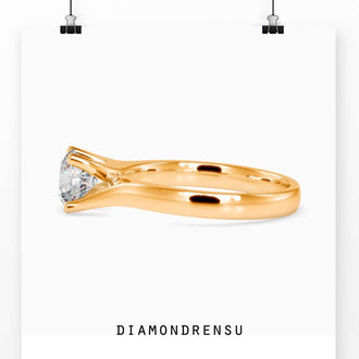 Handmade ring with a bypass solitaire engagement design in gold.