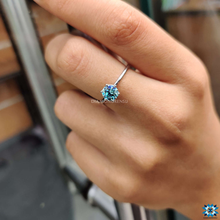 A cyan blue moissanite ring glowing in natural sunlight, ideal for unique styles.