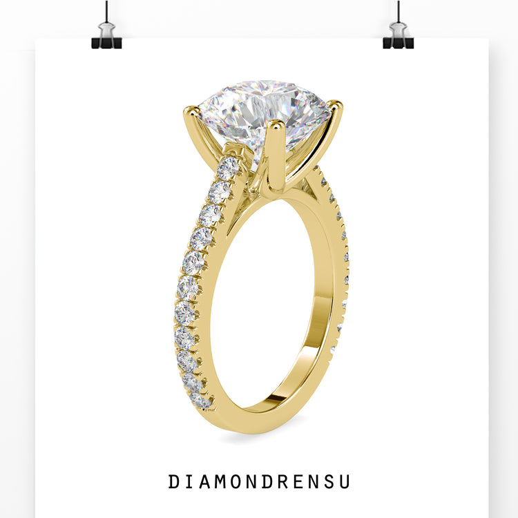 Handmade jewelry featuring a round diamond engagement ring in a cathedral setting with pave details.