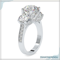 Three stone engagement ring with a classic round cut diamond center.