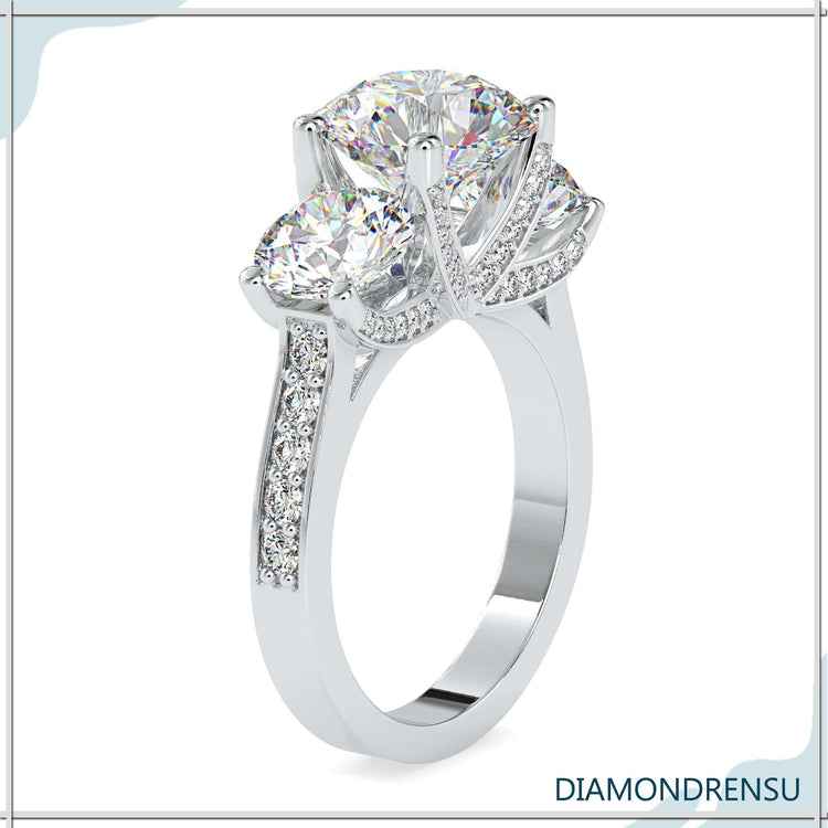 Three stone engagement ring with a classic round cut diamond center.