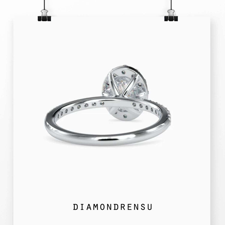 Oval diamond ring with halo and a 4 prong setting, crafted with handmade jewelry techniques.