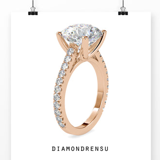 Cathedral setting engagement ring with a 2 carat round brilliant cut diamond and pave ring accents.