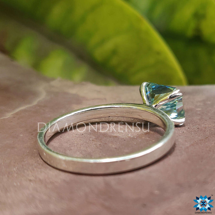 Blue moissanite ring sparkling with vibrant colour.