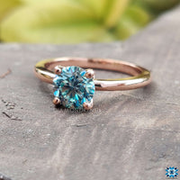 Classic handmade ring featuring a radiant cyan blue moissanite.