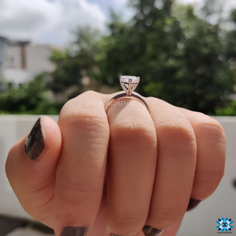 A gold prong ring setting placed on a reflective surface, enhancing its glow.