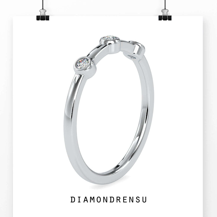 Round diamond wedding band in yellow gold with a bezel setting