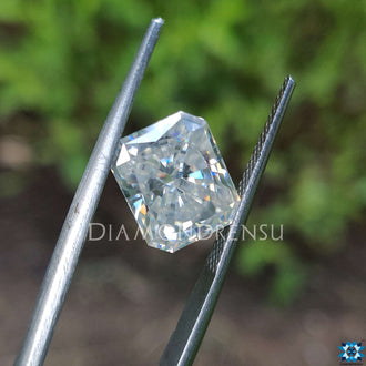 Radiant cut loose stone shining beside moissanite radiant cut.