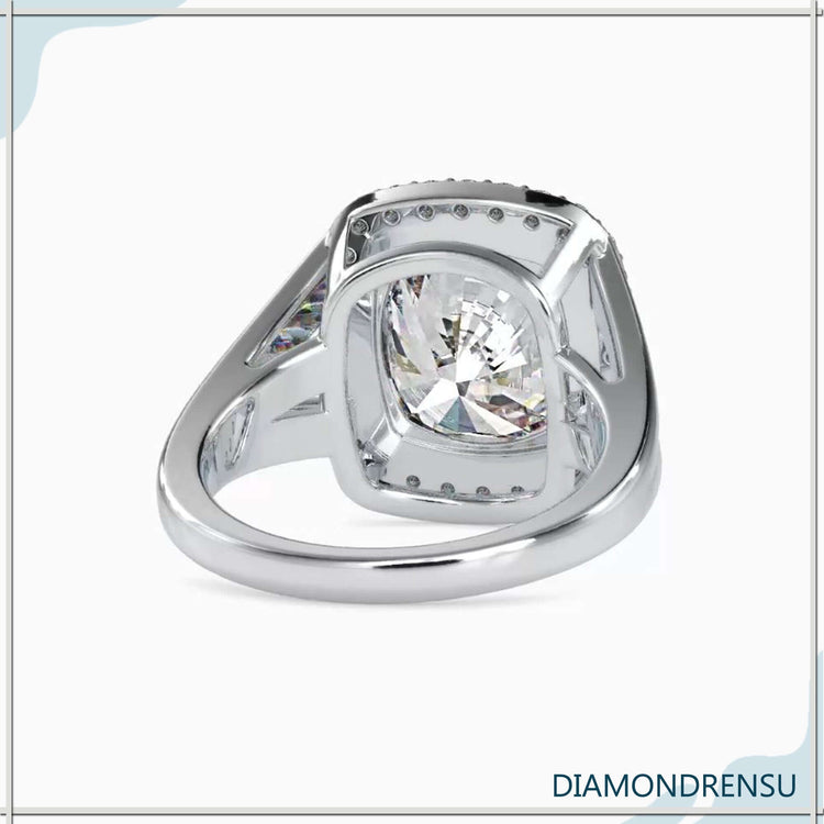 Halo ring cushion featuring a cushion cut diamond and a split shank diamond ring design.