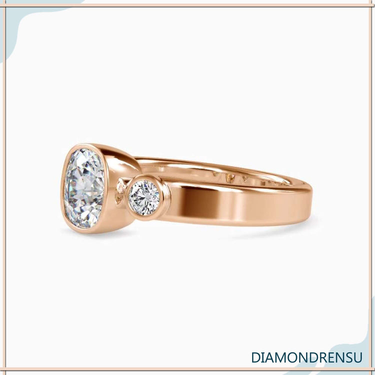 Bezel set engagement ring with 2ct cushion cut diamond in a handmade design.