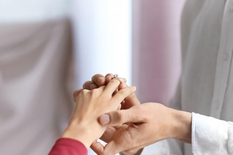 A woman with short finders wearing a diamond ring