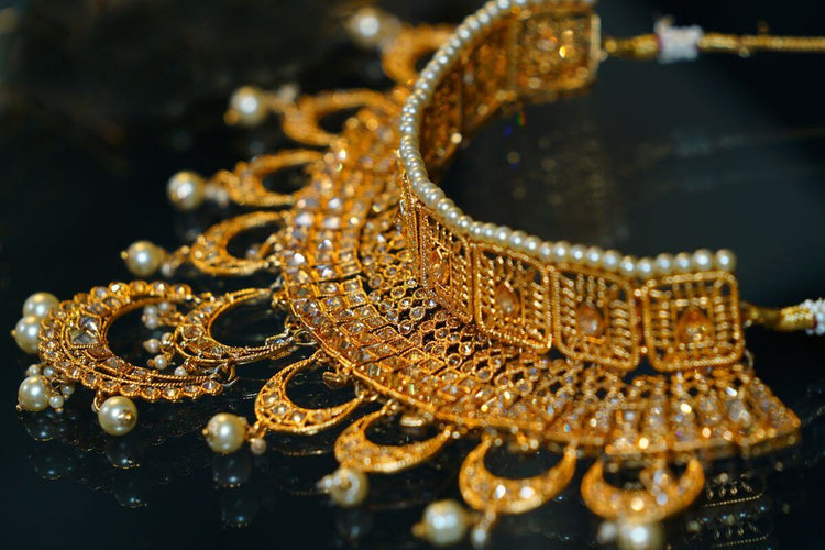 A beautiful milgrain diamond necklace with pearls attached to it.