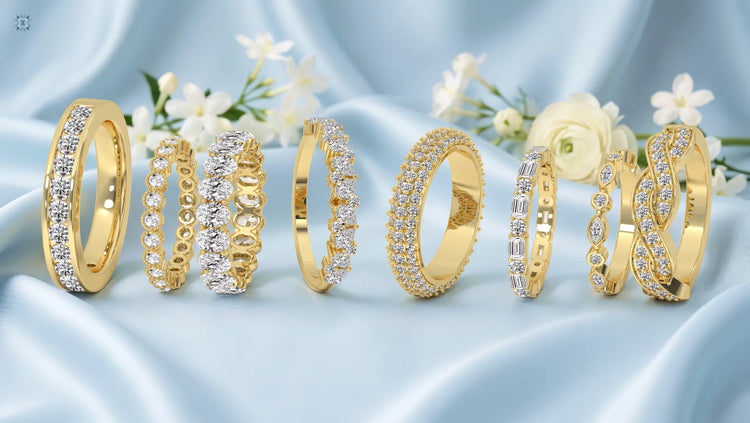 Luxury yellow gold diamond wedding rings arranged on silky blue fabric with floral accents